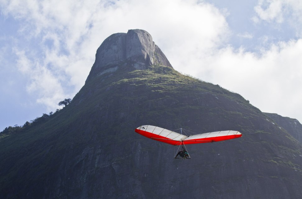 a person flying on a hang glider with a mountain in the background