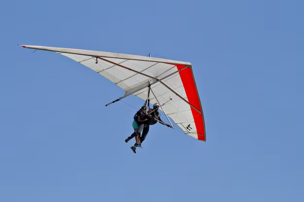Man flying on a hang glider against a background of blue sky
