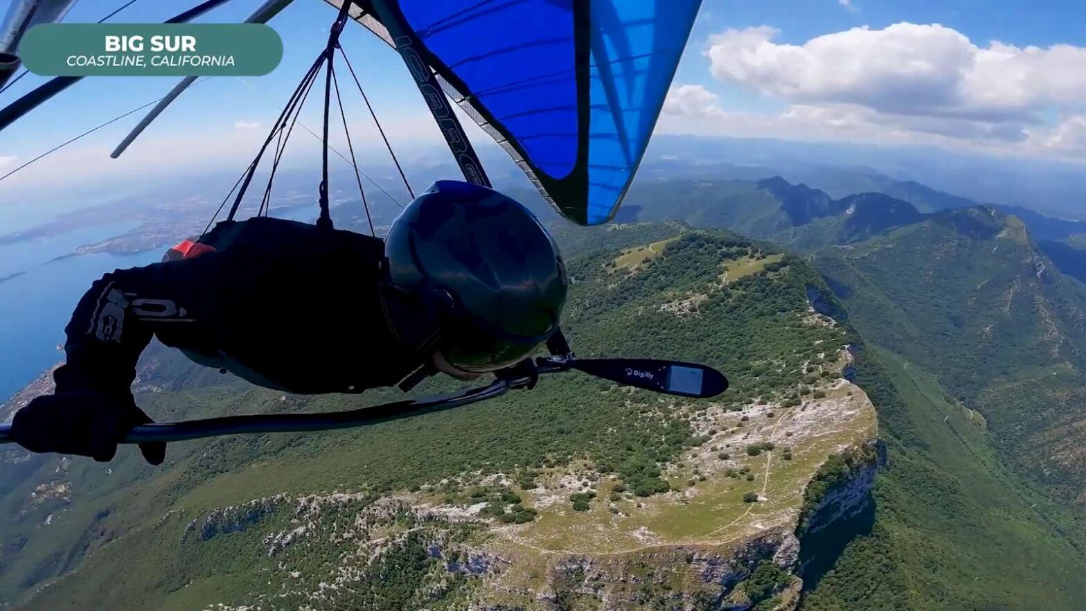 Human flying on a hang glider near mountains