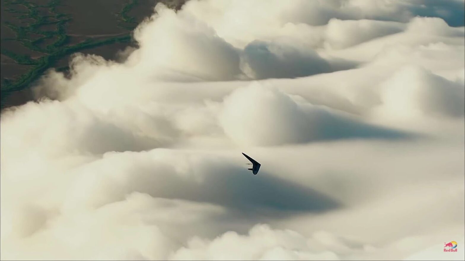 Human flying on a hang glide near clouds