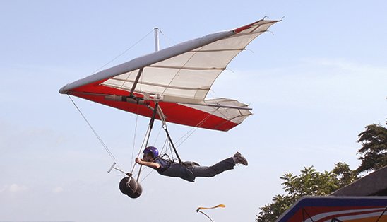 People fly a hang glider