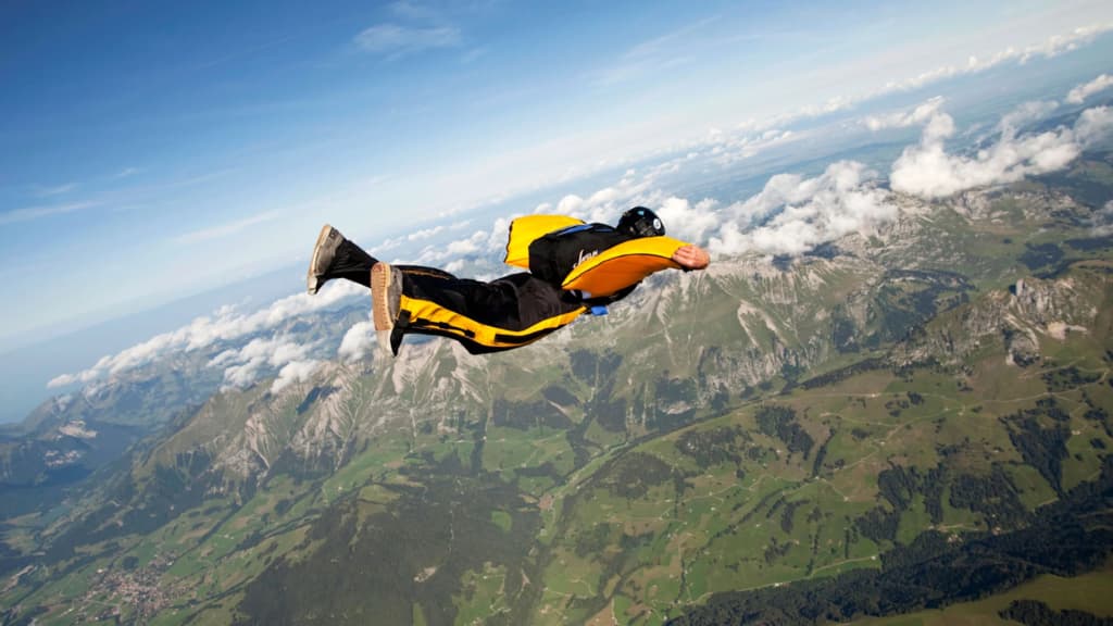 Man in Wingsuit on Mountain Background