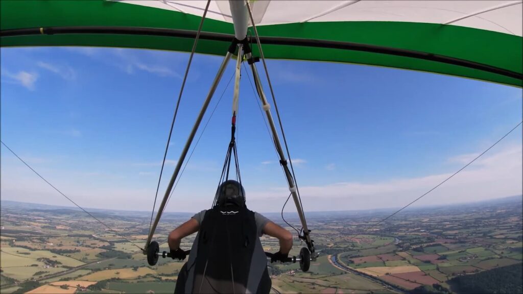 Pilot's view while hang gliding over a lush landscape