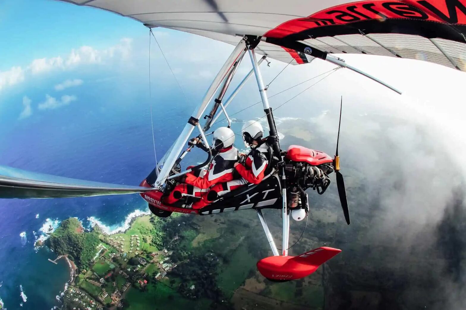 Two people flying a hang glider in Hawaii