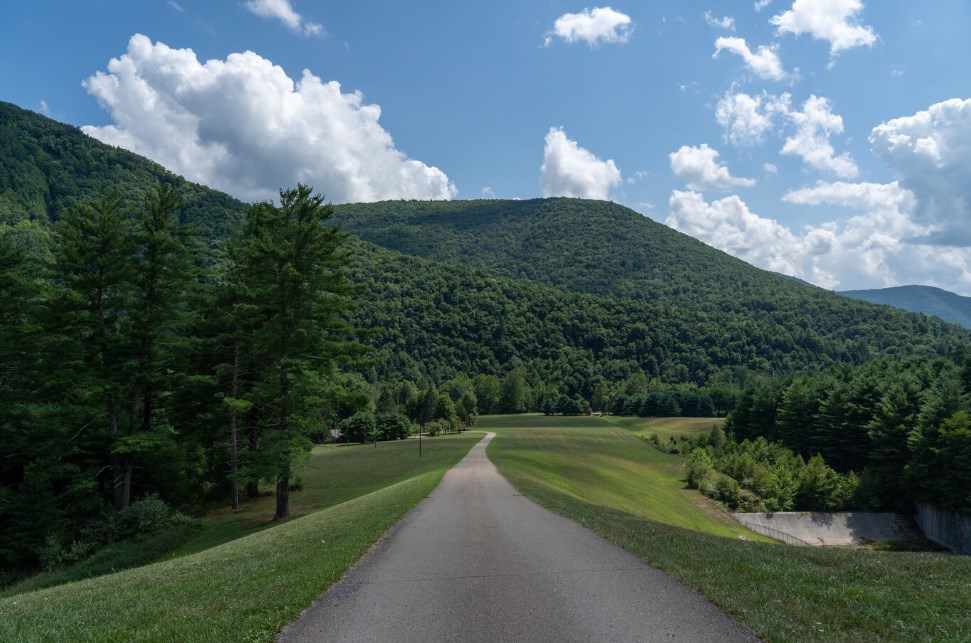 a road leading through green hills under a bright sky in Austin, Pennsylvania