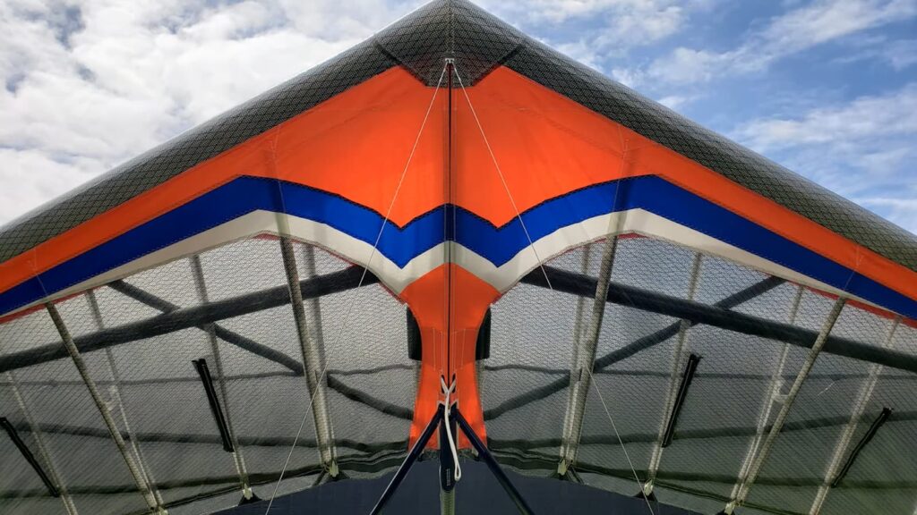 Close-up of a colorful hang glider's wing against the sky