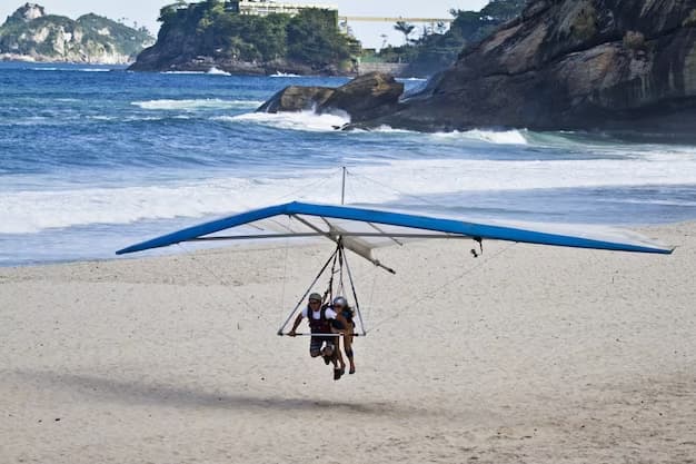 People on the beach riding in a deltoplane
